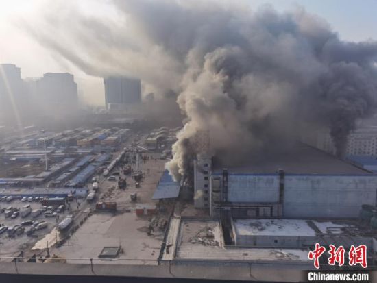1月14日，济南市历下区姚家路银座圣洋物流副产品批发市场的冷库发生火灾。现场浓烟滚滚。　梁�� 摄